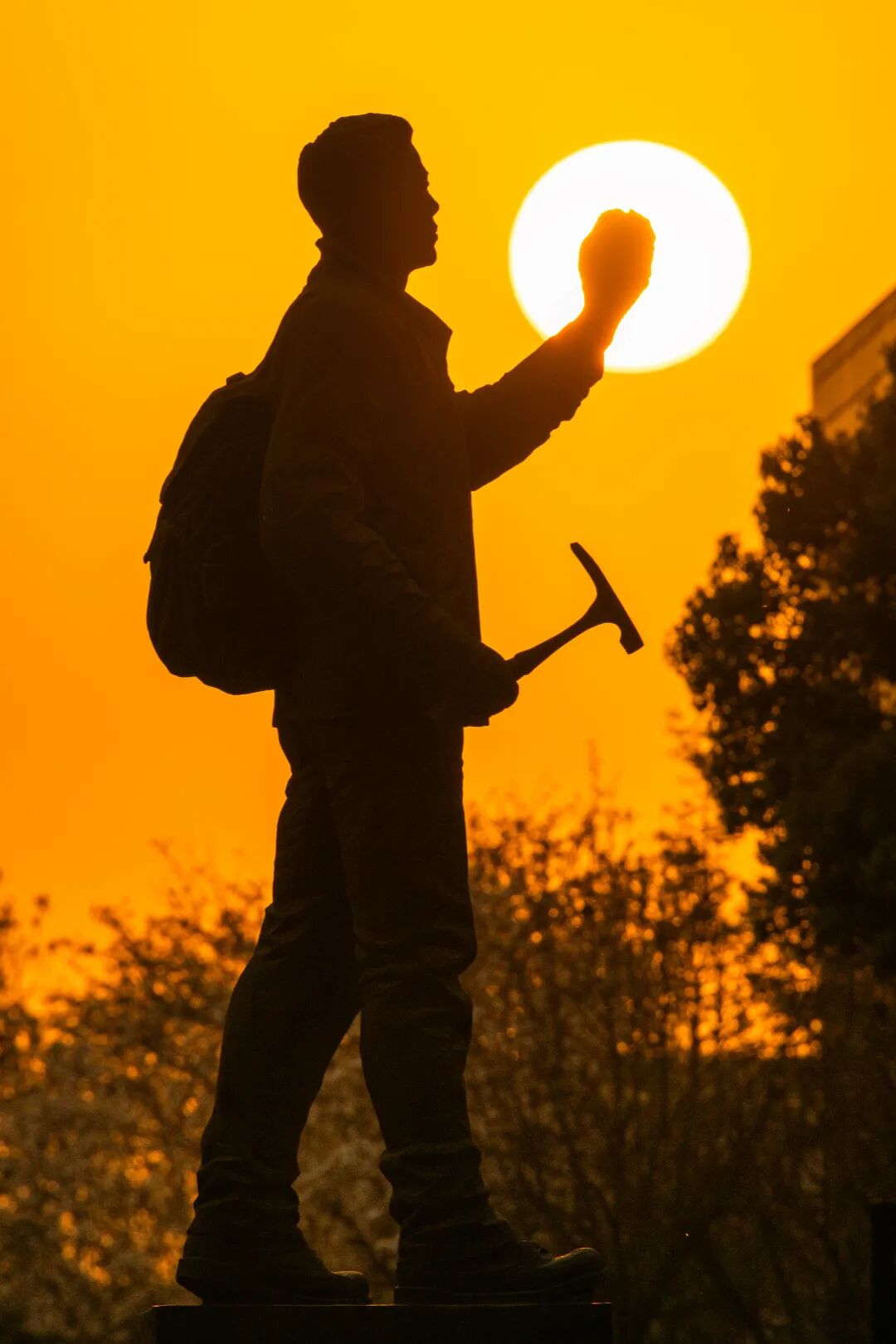 《背着行囊追太阳》（校园内的勘探队员雕像与夕阳同框）.jpg